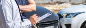 Adjuster inspecting two damaged vehicles.