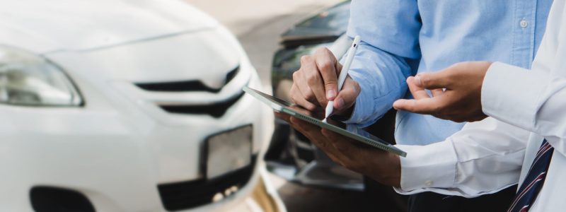 Car insurance concept.Insurance agent and business man filing signature on report claim form process after accident.Traffic Accident and insurance concept.