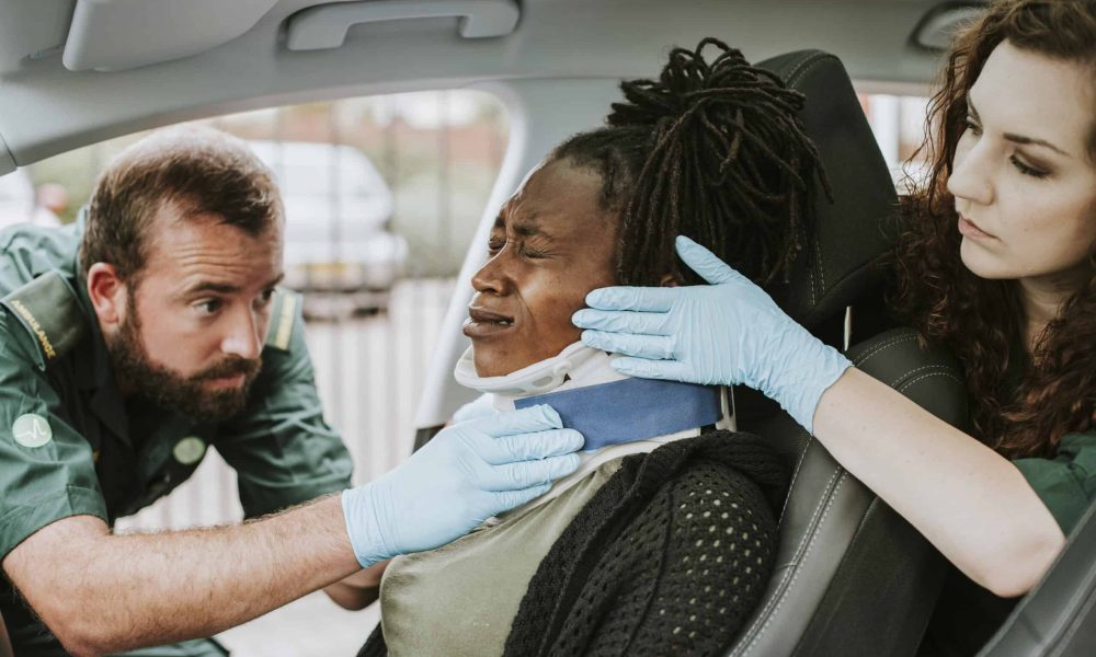 Paramedic placing a cervical collar to an injured woman from car accident Paramedic placing a cervical collar to an injured woman from car accident
